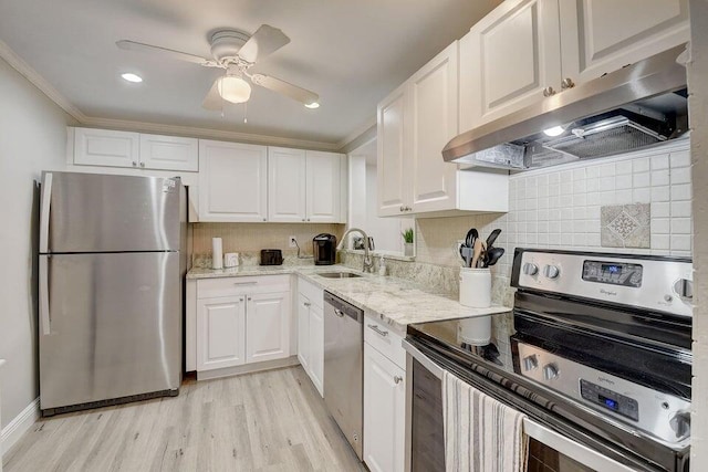 kitchen featuring white cabinets, crown molding, sink, appliances with stainless steel finishes, and light hardwood / wood-style floors