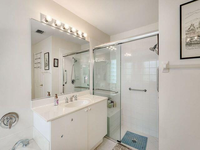 bathroom with vanity and a shower with door