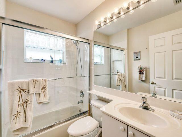 full bathroom featuring vanity, toilet, and enclosed tub / shower combo