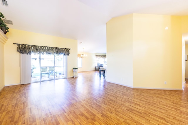 unfurnished living room featuring light hardwood / wood-style flooring and a notable chandelier