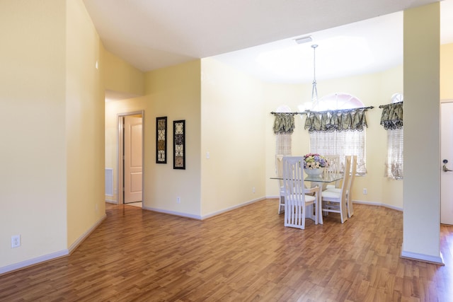 unfurnished dining area with hardwood / wood-style flooring and a notable chandelier