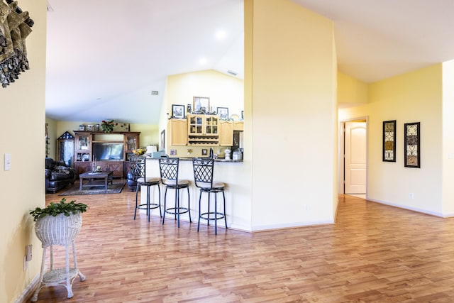 interior space featuring light wood-type flooring and high vaulted ceiling