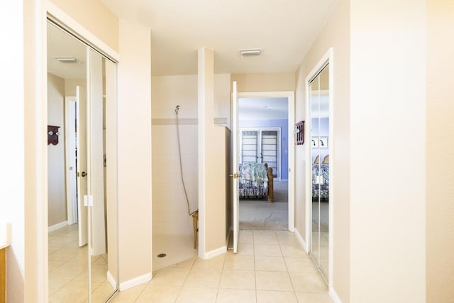 hall featuring light tile patterned floors