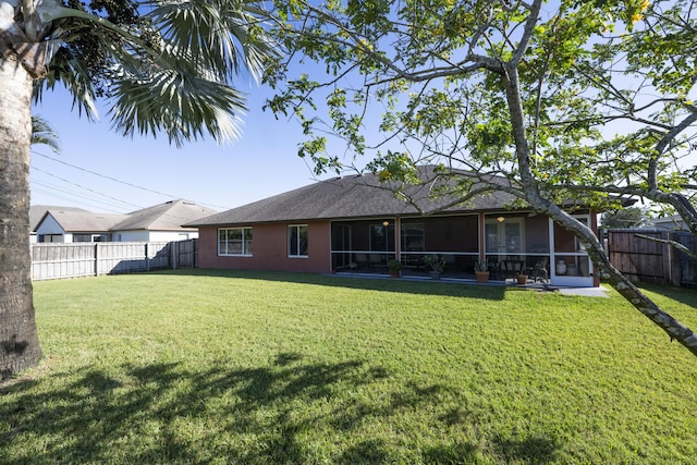 back of property with a lawn and a sunroom