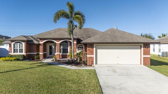 single story home with a garage, a front lawn, and cooling unit