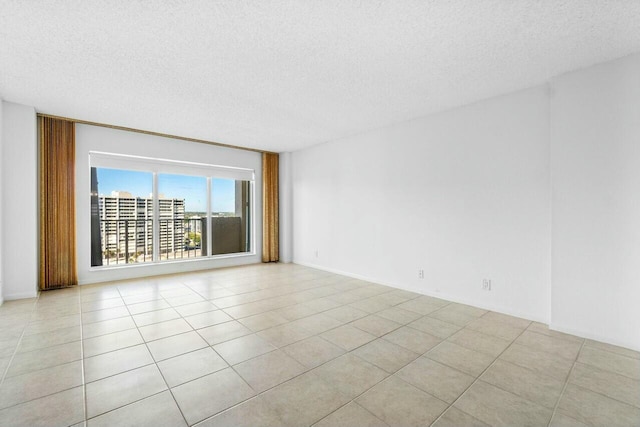 empty room with light tile patterned floors and a textured ceiling