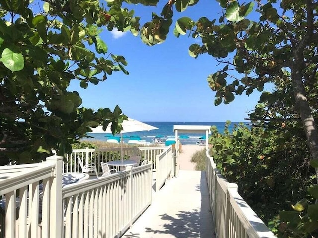 exterior space with a water view and a beach view