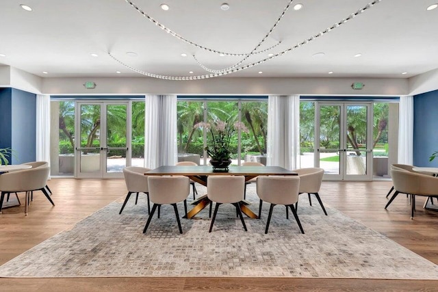 dining space featuring french doors, a healthy amount of sunlight, and light hardwood / wood-style flooring