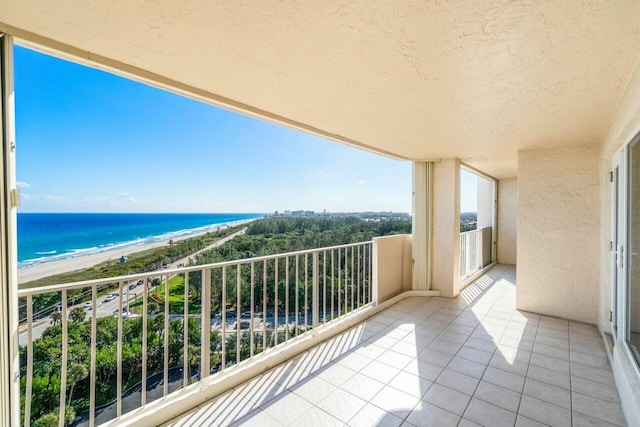 balcony featuring a water view and a beach view