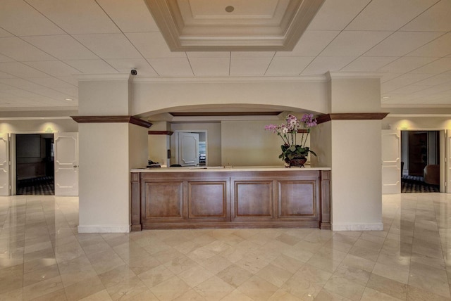 interior space with light tile patterned floors, crown molding, and a tray ceiling