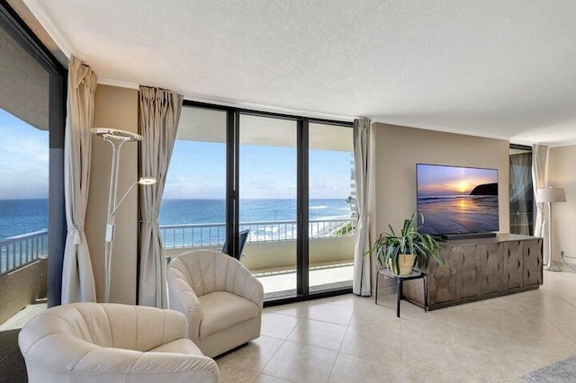 living room featuring a textured ceiling, a water view, expansive windows, and light tile patterned flooring