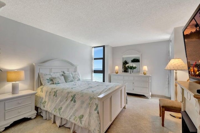 bedroom featuring light tile patterned flooring and a textured ceiling