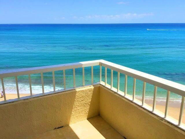 balcony featuring a view of the beach and a water view