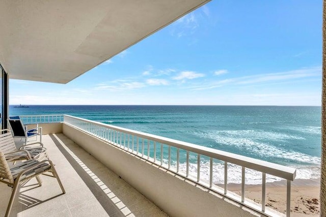 balcony featuring a water view and a view of the beach