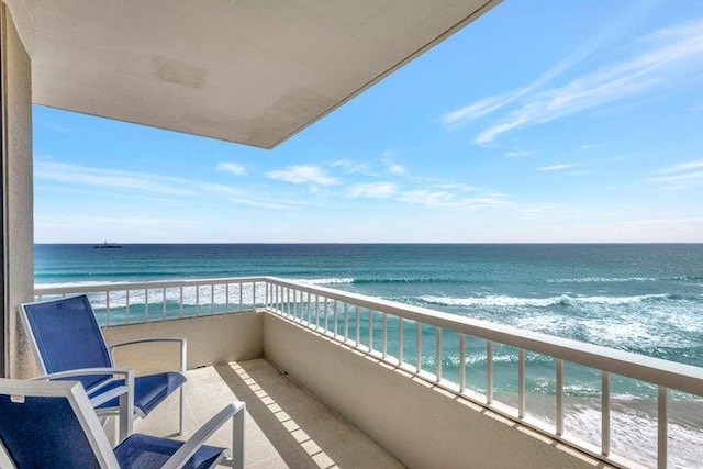 balcony featuring a view of the beach and a water view