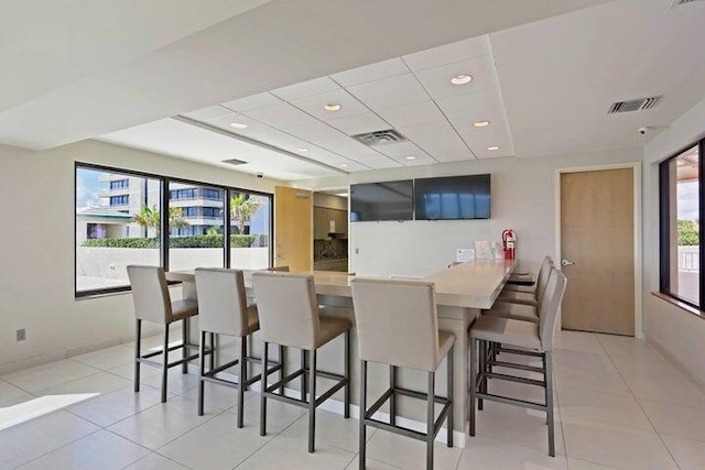 kitchen featuring a kitchen breakfast bar, kitchen peninsula, and light tile patterned floors