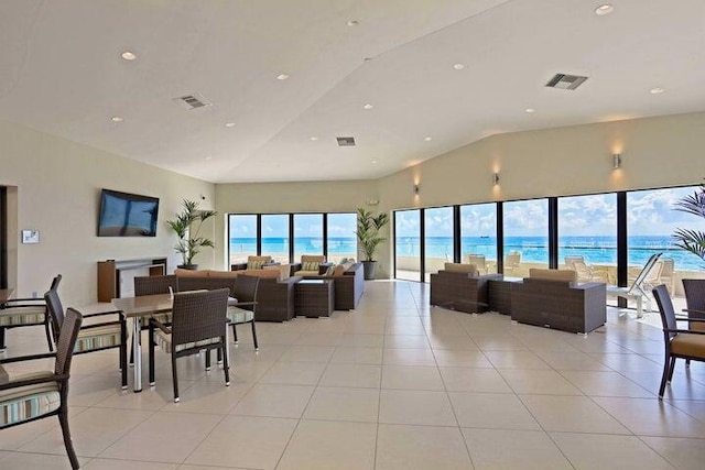 living room featuring a water view, high vaulted ceiling, and light tile patterned flooring