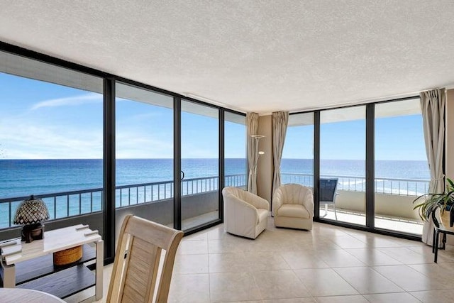 sunroom with a water view and a beach view