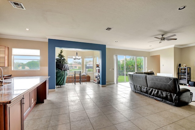 tiled living room featuring a textured ceiling, crown molding, a healthy amount of sunlight, and ceiling fan with notable chandelier