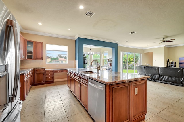 kitchen with sink, light stone counters, crown molding, a center island with sink, and appliances with stainless steel finishes