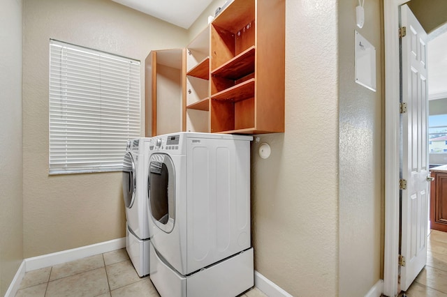 clothes washing area featuring washing machine and clothes dryer and light tile patterned floors