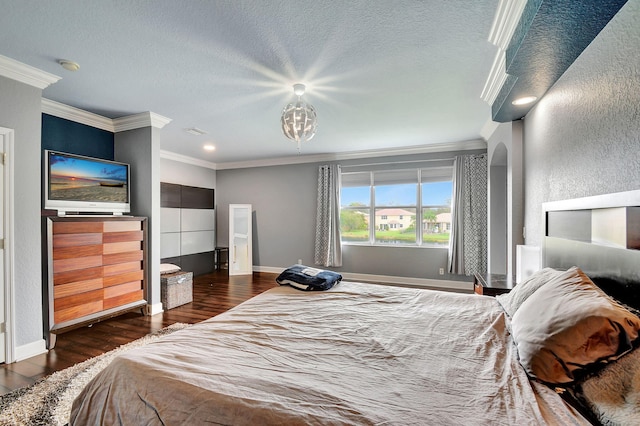 bedroom featuring dark hardwood / wood-style flooring, ornamental molding, and a textured ceiling