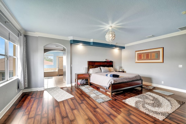 bedroom with hardwood / wood-style floors, a textured ceiling, and ornamental molding