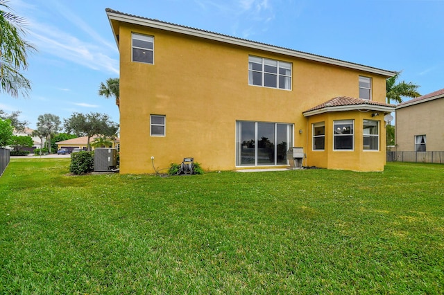 back of house featuring central AC and a yard