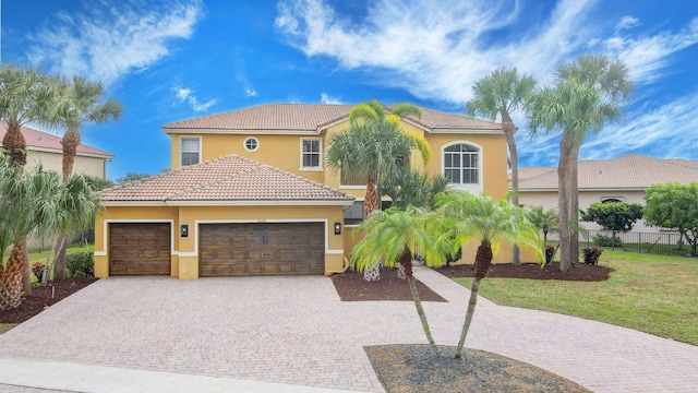 mediterranean / spanish house with a garage and a front lawn