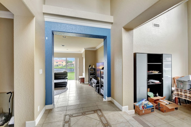 corridor featuring tile patterned floors and crown molding