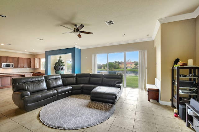 tiled living room featuring a textured ceiling, ceiling fan, and ornamental molding