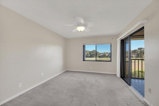 carpeted empty room with ceiling fan and a textured ceiling