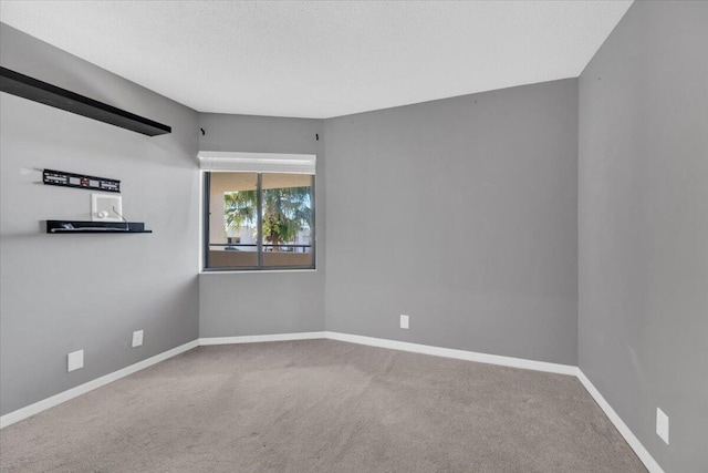 unfurnished room featuring carpet and a textured ceiling