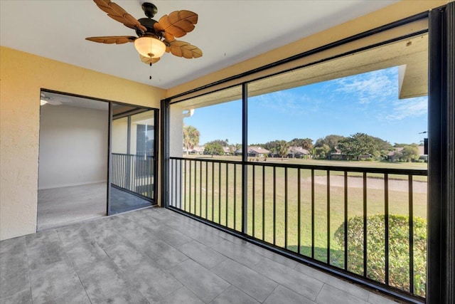 unfurnished sunroom with ceiling fan