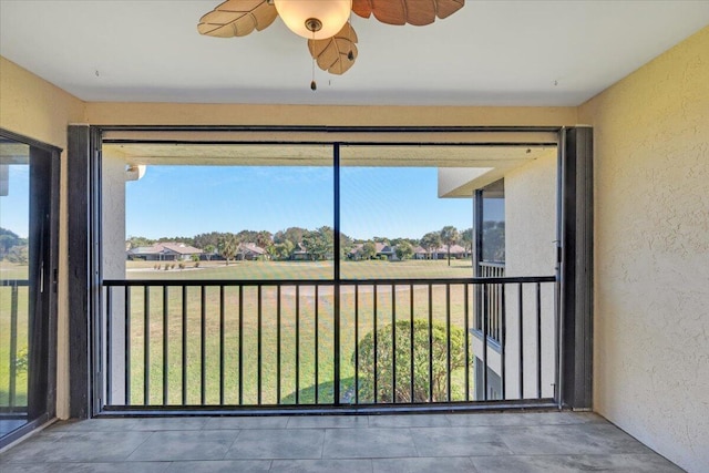 unfurnished sunroom with ceiling fan