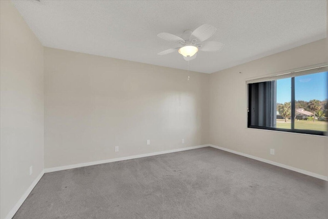 empty room with carpet, ceiling fan, and a textured ceiling