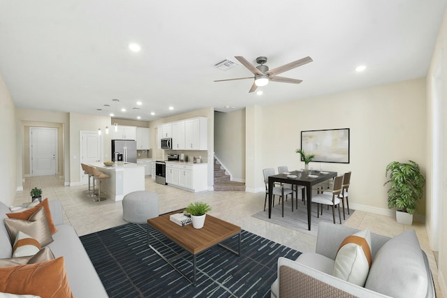 living area featuring stairs, light tile patterned floors, recessed lighting, and visible vents