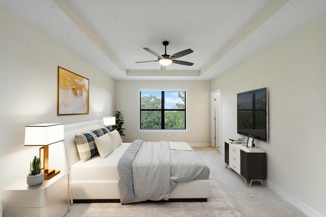 bedroom featuring a ceiling fan, a tray ceiling, light colored carpet, and baseboards