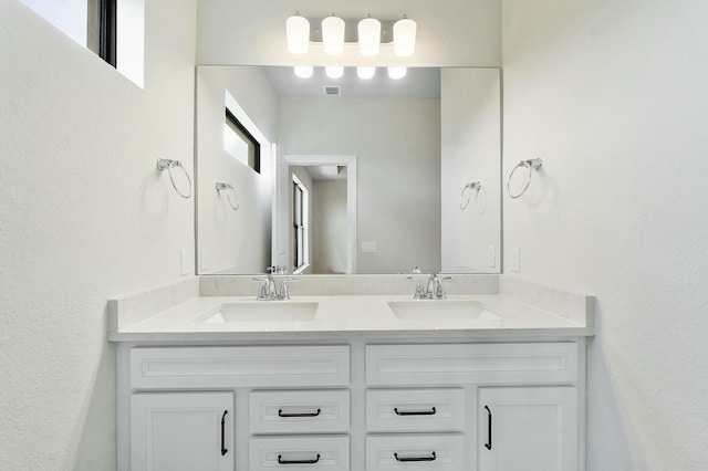 full bathroom with a sink, visible vents, and double vanity