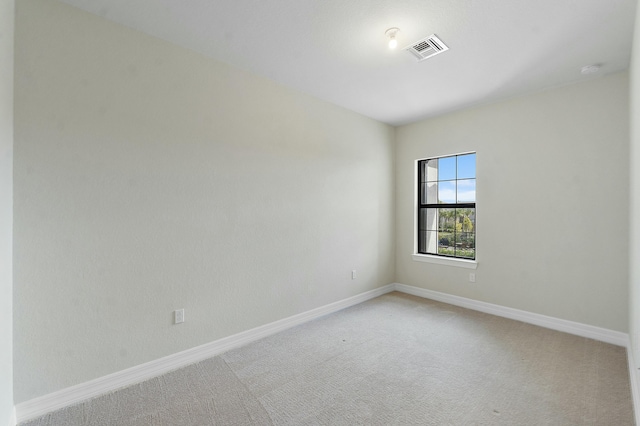 empty room with light carpet, visible vents, and baseboards