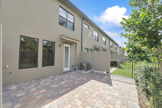 back of property featuring a patio area, cooling unit, fence, and stucco siding