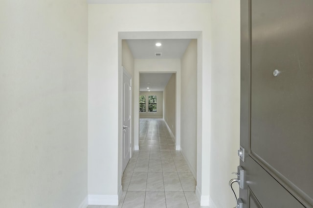 hall featuring visible vents and baseboards