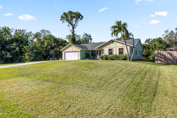 ranch-style home featuring a garage and a front yard