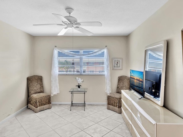 sitting room featuring light tile patterned floors, a textured ceiling, and ceiling fan