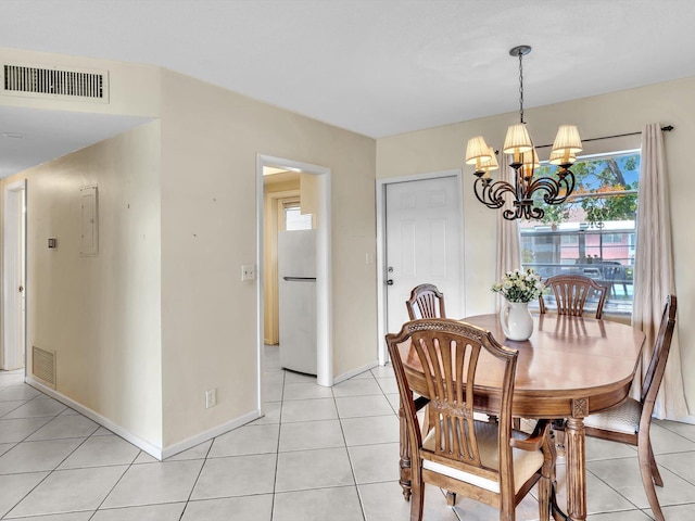 tiled dining area with an inviting chandelier