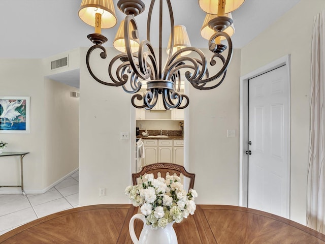 dining space with light tile patterned floors, a notable chandelier, and sink