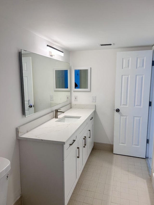 bathroom featuring tile patterned flooring, vanity, and toilet