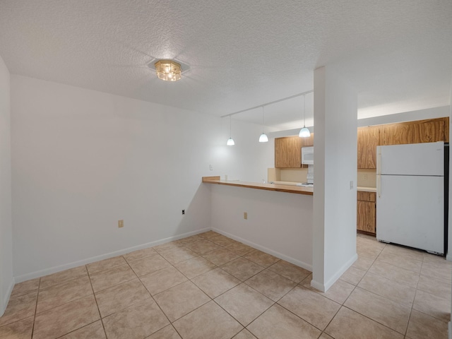 tiled empty room featuring a textured ceiling