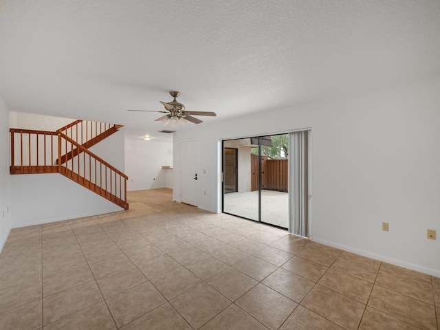 unfurnished room with a textured ceiling, ceiling fan, and light tile patterned flooring