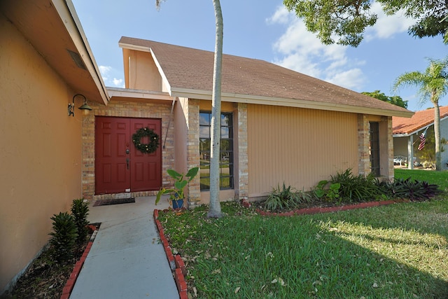 entrance to property featuring a lawn